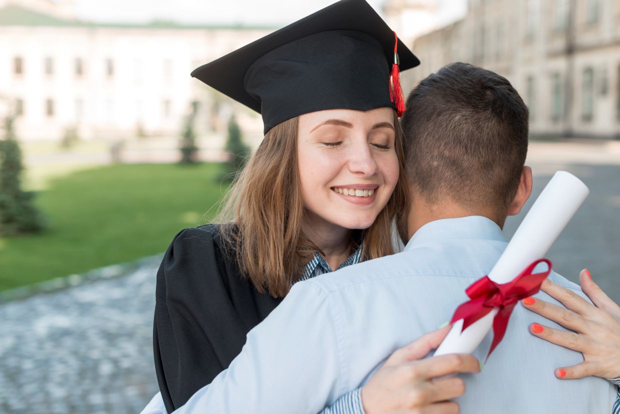 Young graduate in cap and gown celebrating